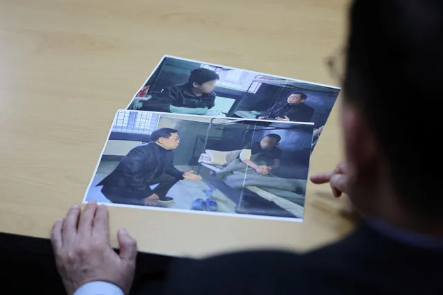 O parlamentar Yu Yong-weon, do principal partido de oposição da Coreia do Sul, o Partido do Poder Popular, explica fotografias que mostram dois prisioneiros de guerra norte-coreanos recentemente transferidos da Ucrânia para a Coreia do Sul, tiradas durante sua visita a um campo de prisioneiros na Ucrânia em fevereiro passado, em seu gabinete na Assembleia Nacional em Seul, Coreia do Sul, em 28 de setembro de 2026. Os rostos dos prisioneiros estão desfocados por motivos de segurança pela fonte. REUTERS/
